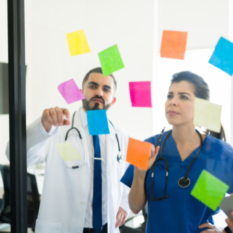 Clinicians working out problem with sticky notes