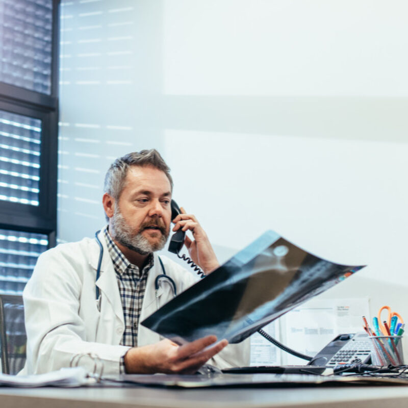 Doctor on phone examining xray