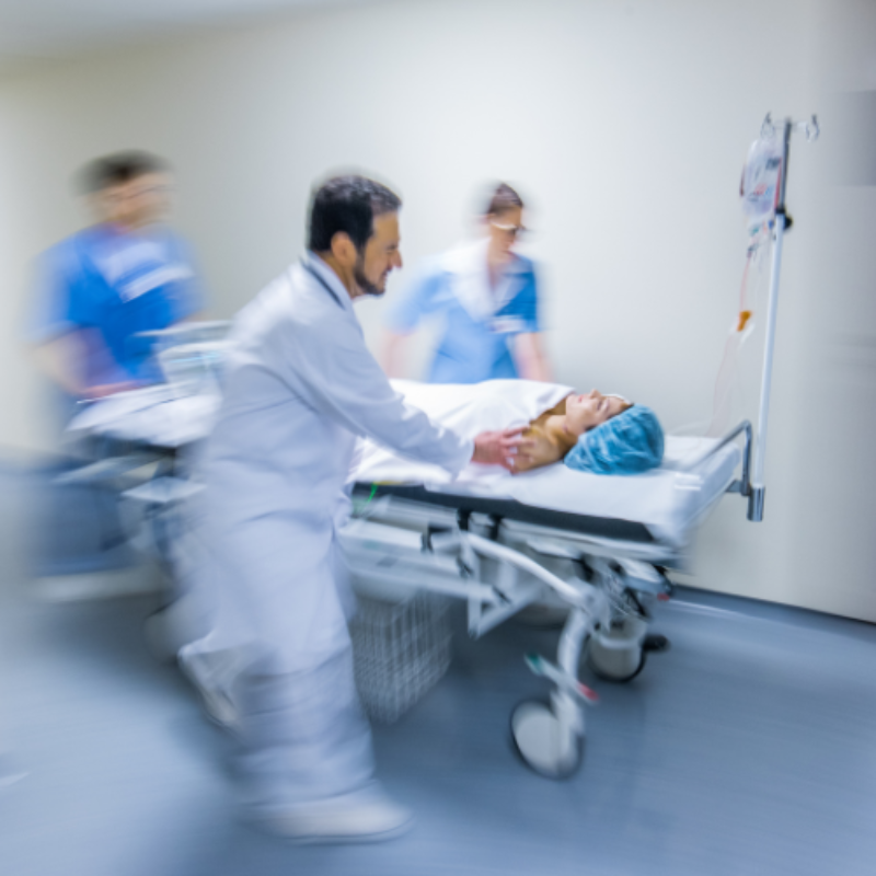 Doctors rushing patient on stretcher down corridor