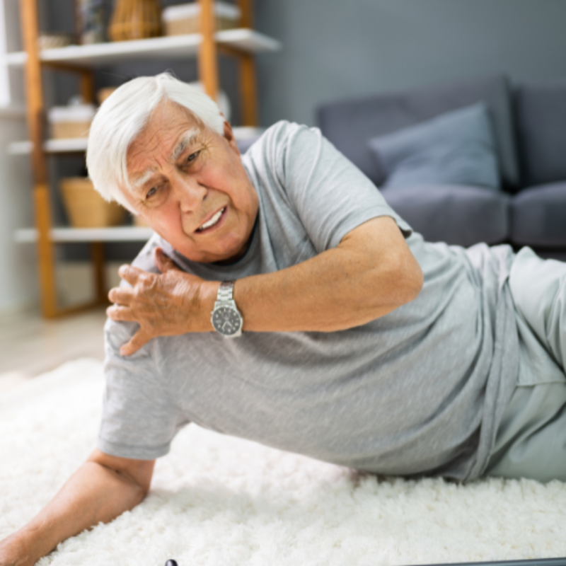 Elderly man holding shoulder after fall