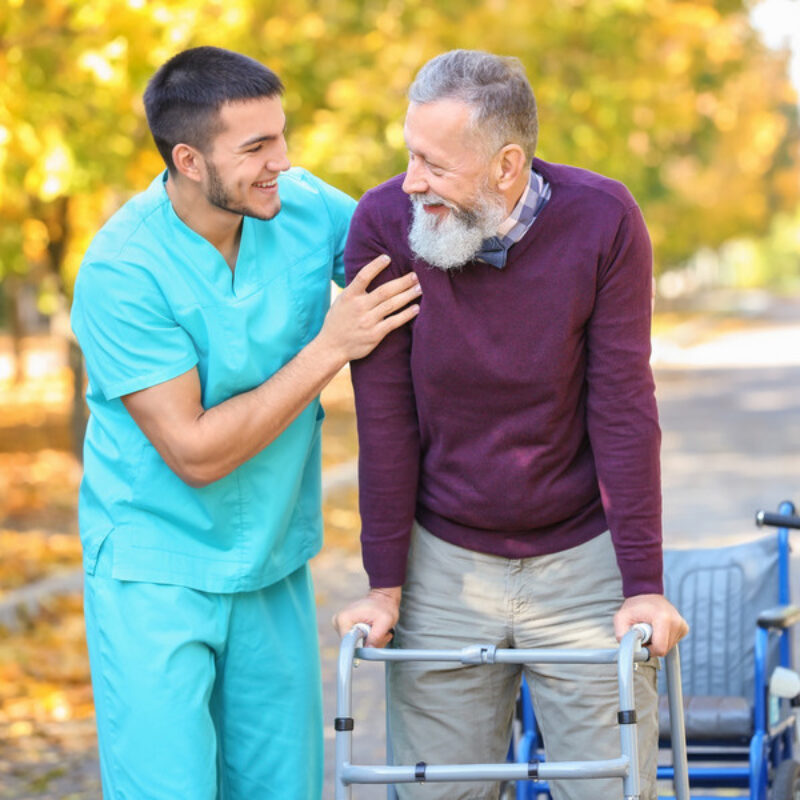 Male nurse retrieving eloping elderly patient with walking frame