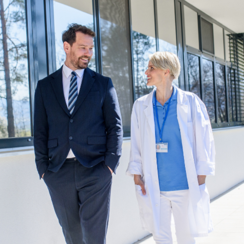 Man in business suit walking with woman doctor