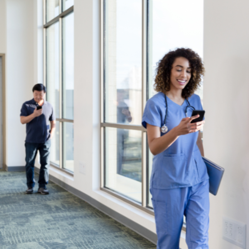 Nurse in corridor using mobile phone