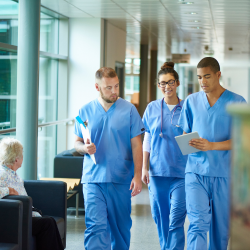 Trio of young doctors in blue scrubs