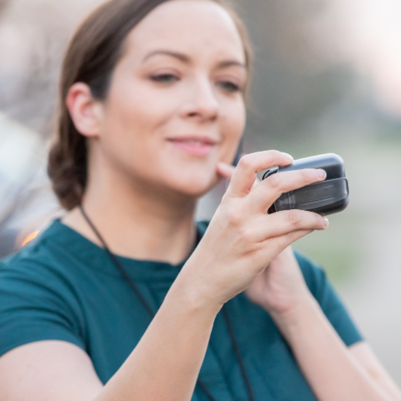 Woman in green shirt reading her pager