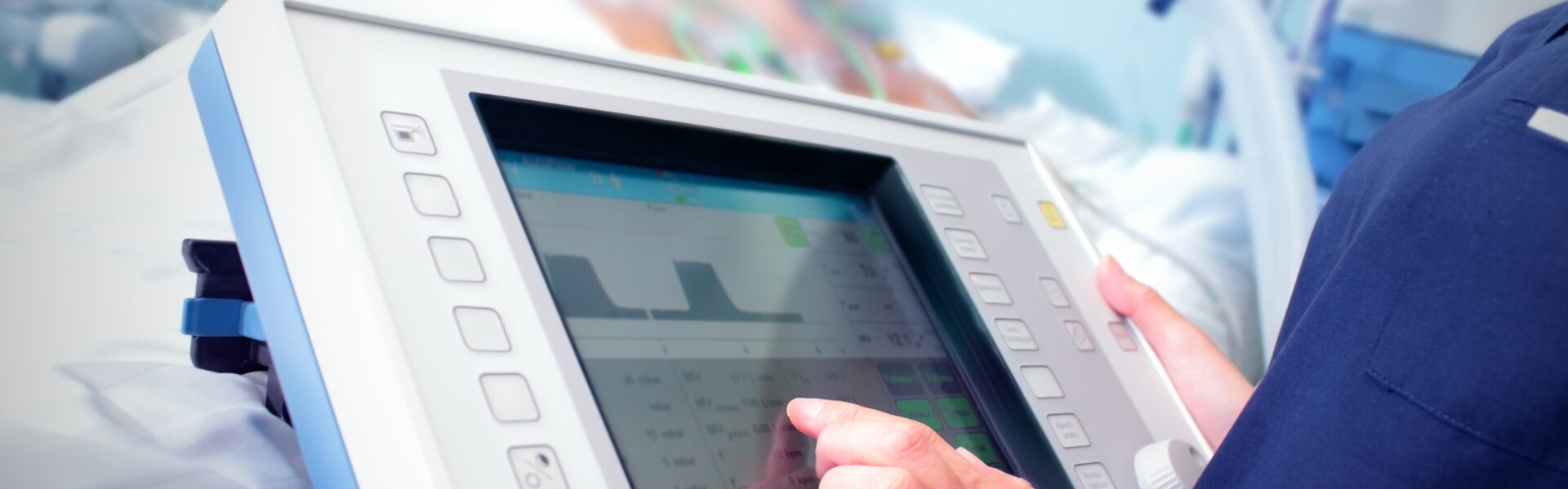 Closeup of nurse using connected device at patient bedside